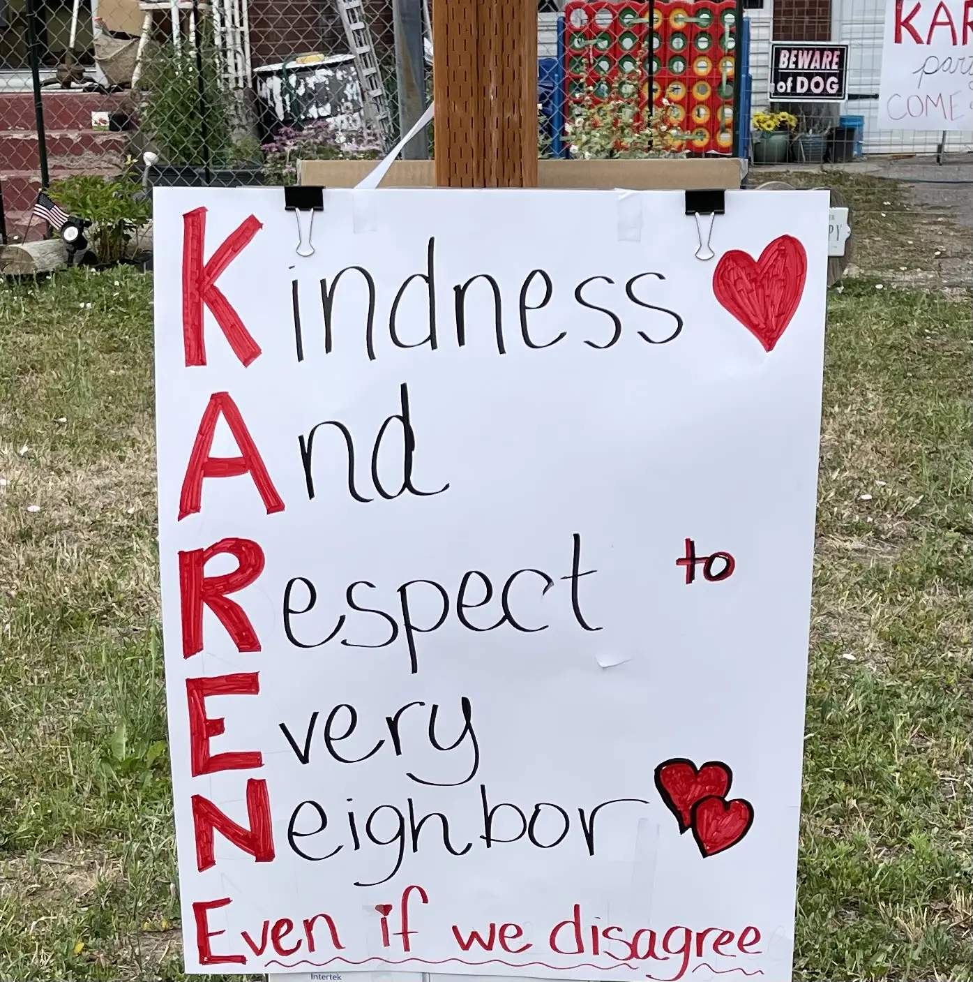 the sign for Karen's first kindness party in front of karen's house says "kindness and respect to every neighbor, even if we disagree."